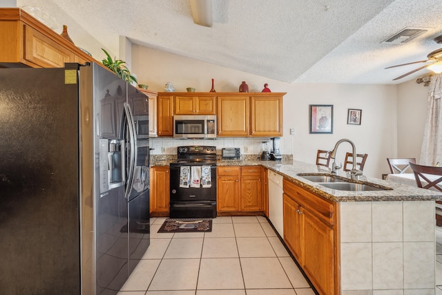 kitchen with sink, appliances with stainless steel finishes, kitchen peninsula, and a textured ceiling