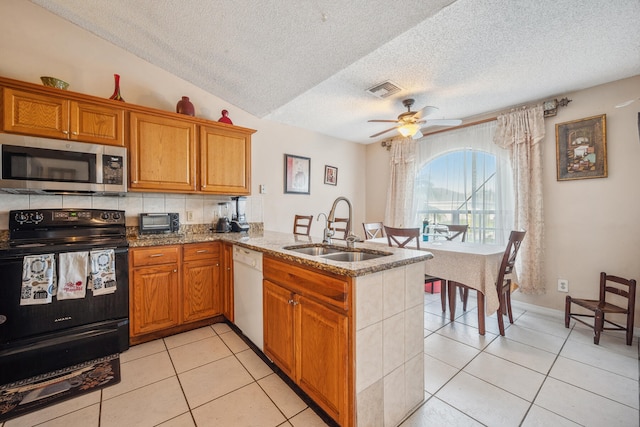 kitchen featuring kitchen peninsula, black electric range oven, white dishwasher, vaulted ceiling, and sink