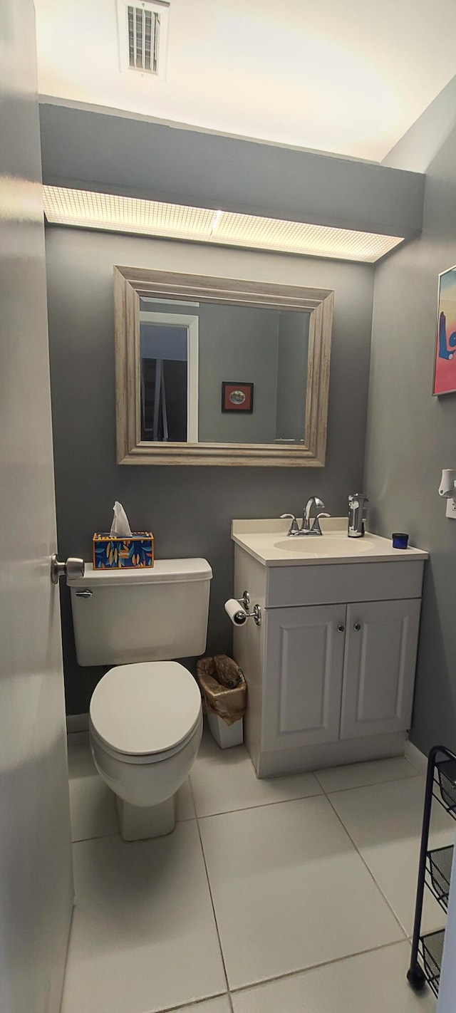 half bathroom featuring toilet, visible vents, tile patterned flooring, and vanity