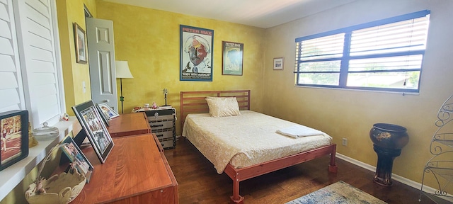 bedroom with baseboards and dark wood-type flooring