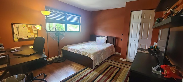 bedroom featuring baseboards, a closet, and wood finished floors