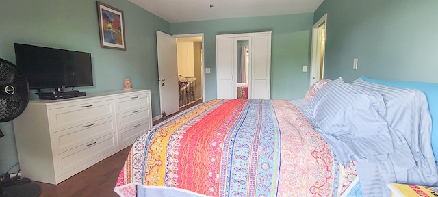 bedroom with ensuite bath and dark hardwood / wood-style flooring