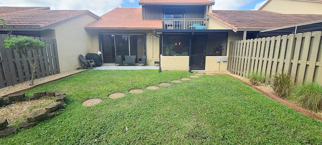 rear view of house with a patio area and a lawn