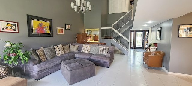 living room featuring an inviting chandelier, a towering ceiling, tile patterned floors, and stairway