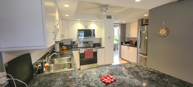 kitchen with backsplash, sink, white cabinetry, appliances with stainless steel finishes, and ceiling fan