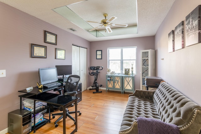 office area with ceiling fan, a textured ceiling, and light wood-type flooring