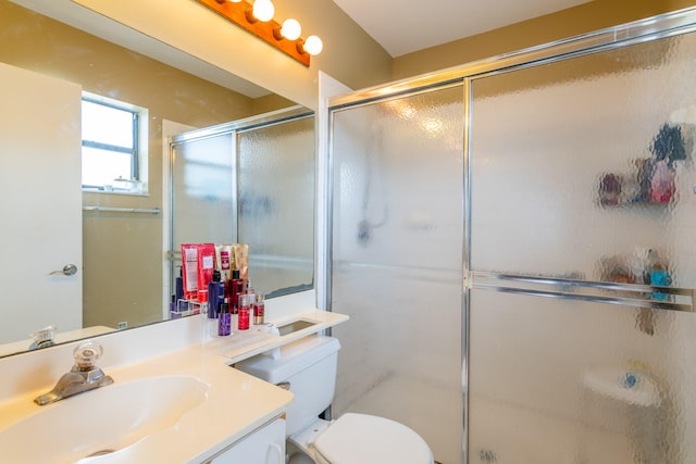 bathroom with toilet, a shower with shower door, and vanity