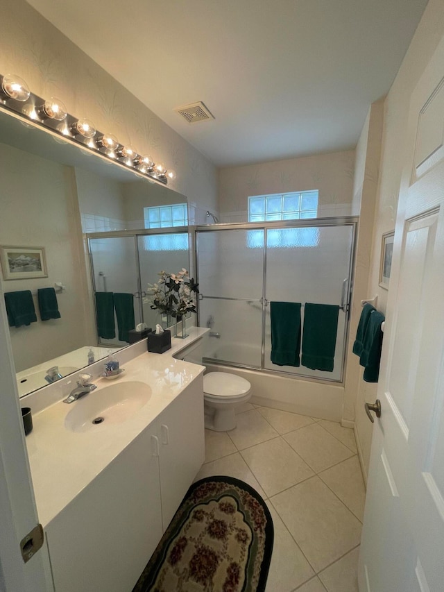 full bathroom with toilet, vanity, tile patterned floors, and shower / bath combination with glass door