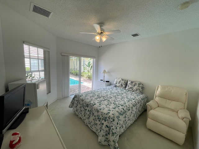 carpeted bedroom featuring ceiling fan, access to outside, and a textured ceiling