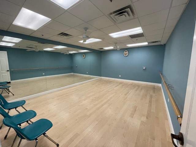 interior space with a drop ceiling and light hardwood / wood-style floors