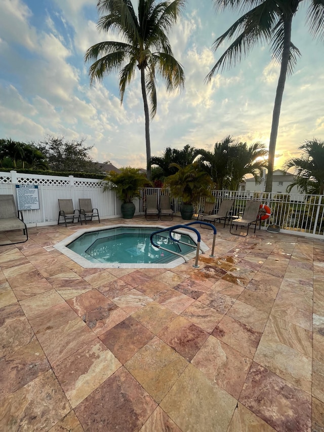 pool at dusk with a patio area