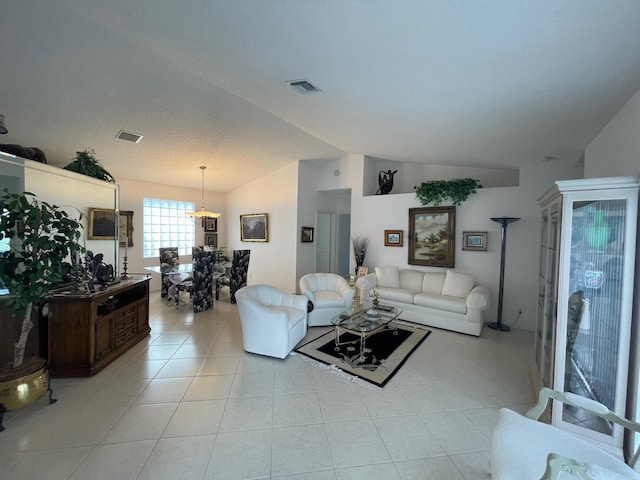 tiled living room with a notable chandelier and lofted ceiling