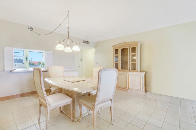 tiled dining room with a chandelier