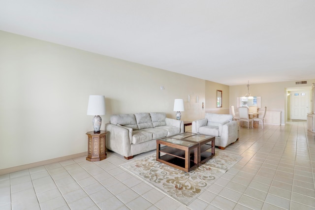 tiled living room featuring a notable chandelier