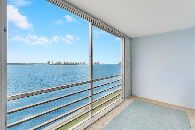 unfurnished sunroom featuring a water view and plenty of natural light