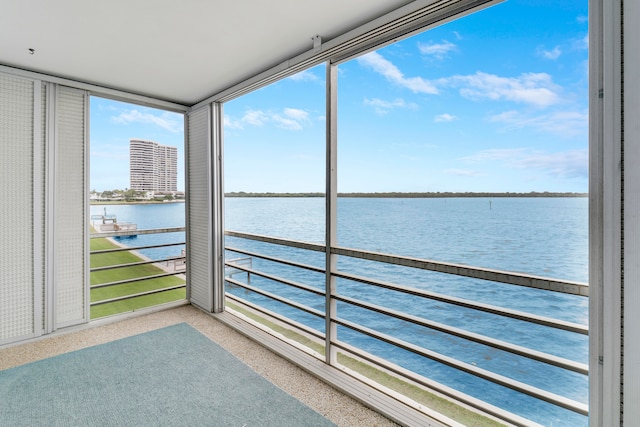 unfurnished sunroom with a water view