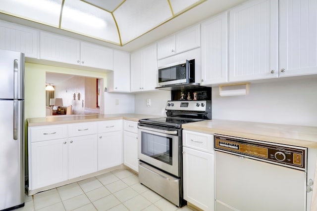 kitchen with white cabinetry, stainless steel appliances, and light tile patterned floors