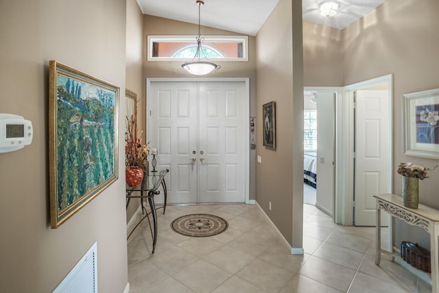 entrance foyer with light tile patterned floors, high vaulted ceiling, and a wealth of natural light