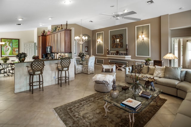 tiled living room featuring vaulted ceiling and ceiling fan with notable chandelier