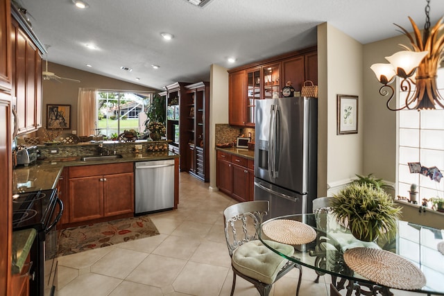 kitchen with decorative backsplash, vaulted ceiling, light tile patterned flooring, sink, and stainless steel appliances