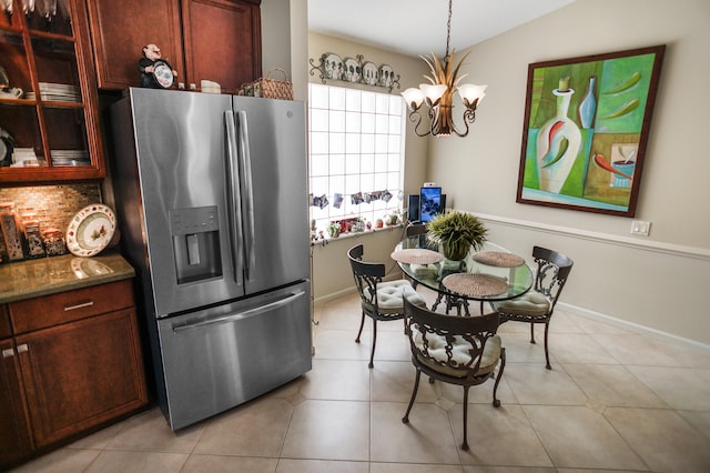 kitchen with a notable chandelier, stainless steel fridge, light tile patterned floors, and pendant lighting