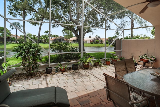 view of patio featuring a water view and glass enclosure