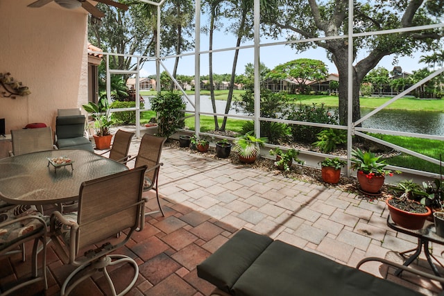 sunroom featuring a water view and ceiling fan