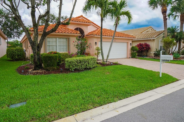 mediterranean / spanish house featuring a front yard and a garage