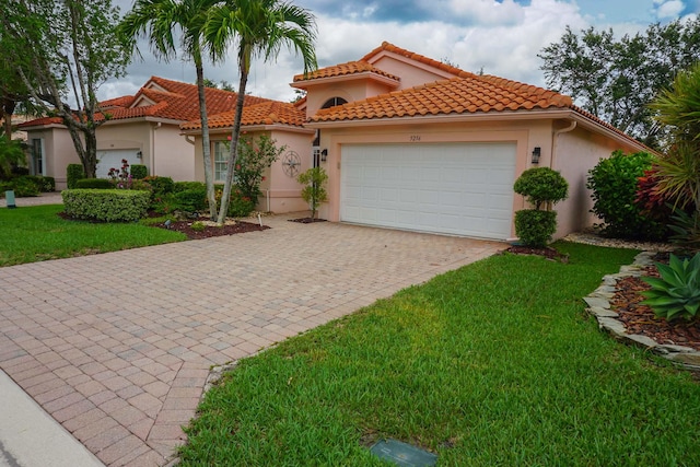 mediterranean / spanish home with a front yard and a garage