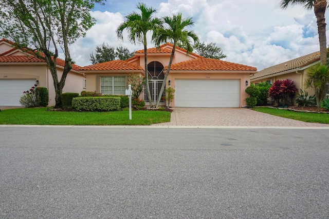 mediterranean / spanish-style house with a front yard and a garage