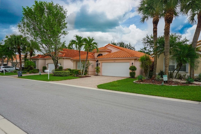 mediterranean / spanish-style home with a front yard and a garage