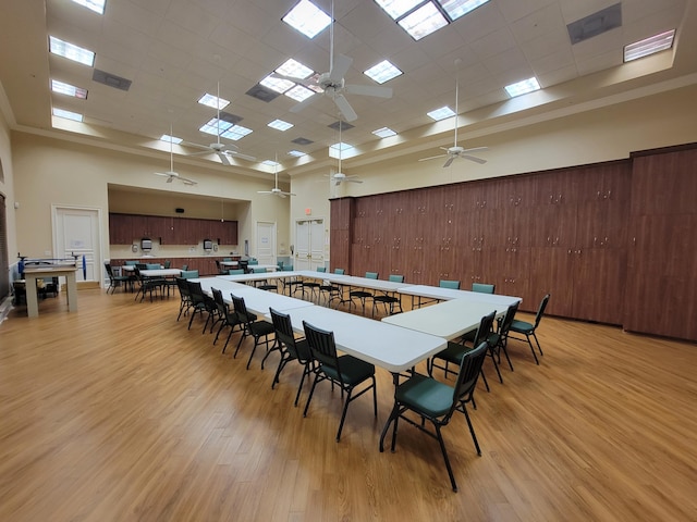 dining room featuring light hardwood / wood-style flooring, a paneled ceiling, a high ceiling, and ceiling fan