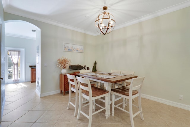 tiled dining area featuring a notable chandelier and ornamental molding