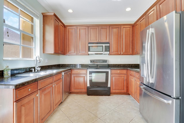 kitchen featuring light tile patterned flooring, stainless steel appliances, sink, and dark stone counters