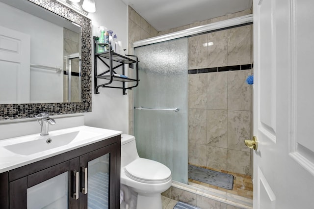 bathroom with vanity, tile patterned flooring, toilet, and walk in shower