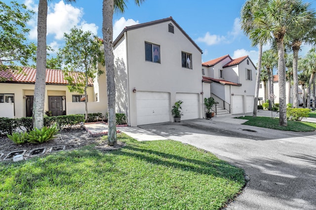 mediterranean / spanish-style home featuring a garage and a front lawn