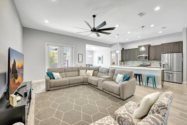 living room with light hardwood / wood-style floors and ceiling fan