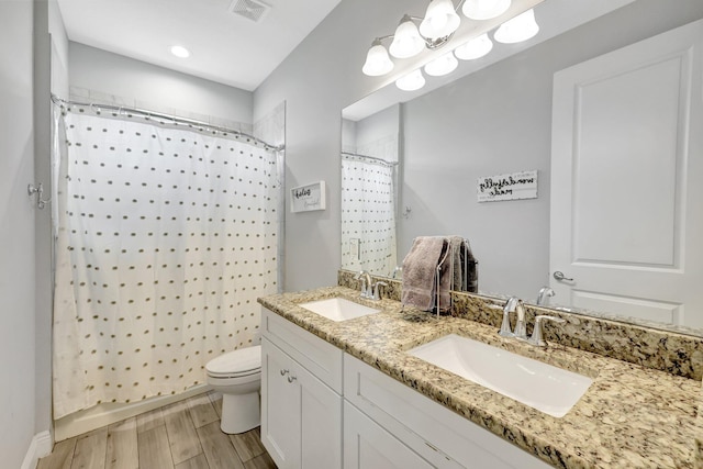 bathroom featuring vanity, curtained shower, wood-type flooring, and toilet