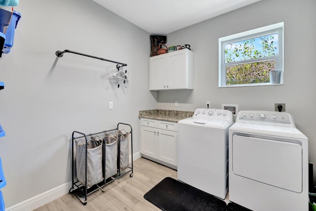 laundry area with cabinets, light hardwood / wood-style flooring, and washer and dryer