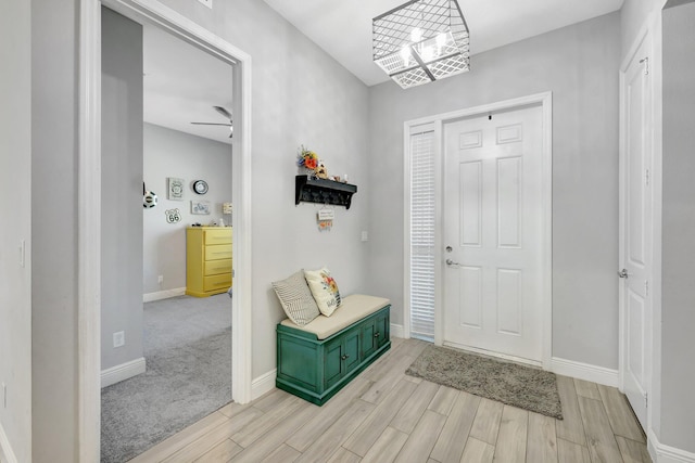 foyer featuring light hardwood / wood-style floors and ceiling fan with notable chandelier