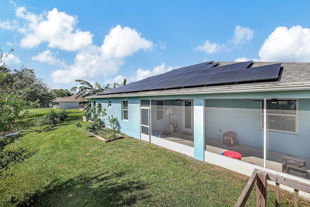 back of property featuring a patio area, solar panels, and a yard