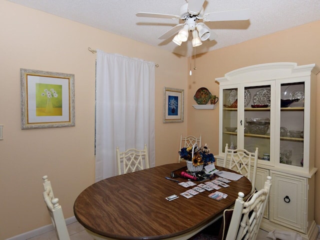 tiled dining space featuring ceiling fan and a textured ceiling