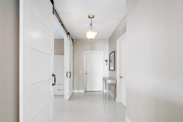 corridor featuring a barn door and light tile patterned flooring