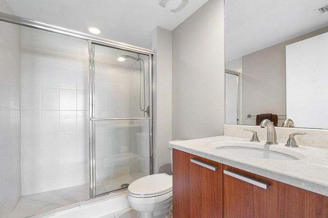 bathroom featuring toilet, vanity, and a shower with shower door