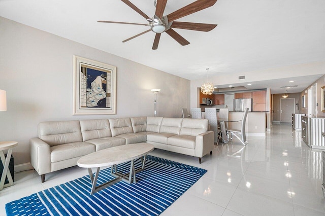 living room featuring ceiling fan with notable chandelier and light tile patterned flooring