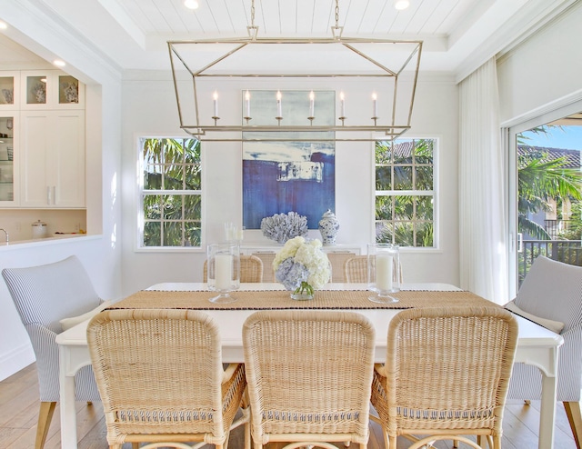 dining space with a raised ceiling and ornamental molding