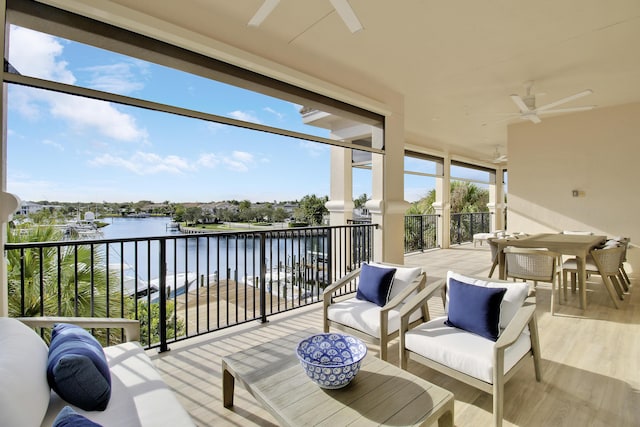 sunroom / solarium featuring ceiling fan and a water view