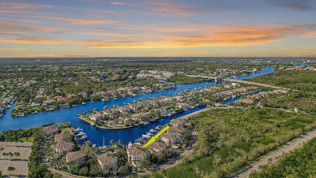 aerial view at dusk featuring a water view