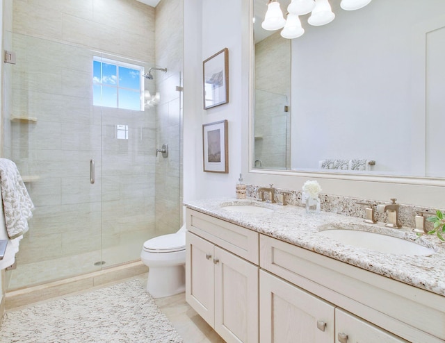 bathroom featuring tile patterned floors, vanity, a shower with shower door, and toilet