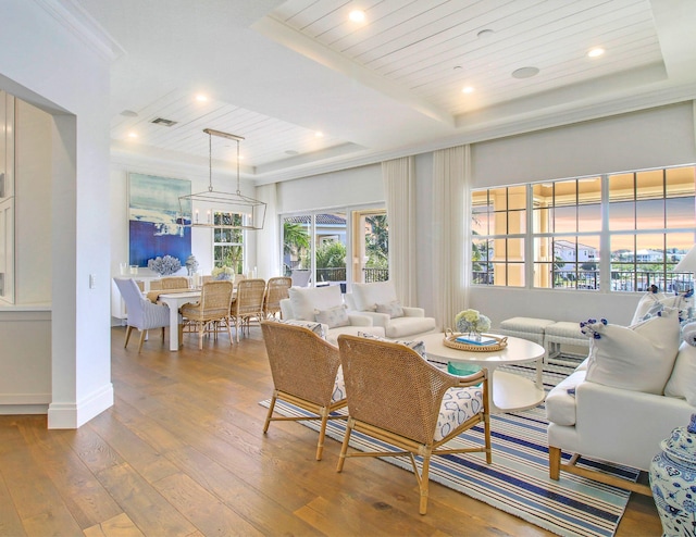 living room with wood-type flooring, a tray ceiling, plenty of natural light, and wooden ceiling